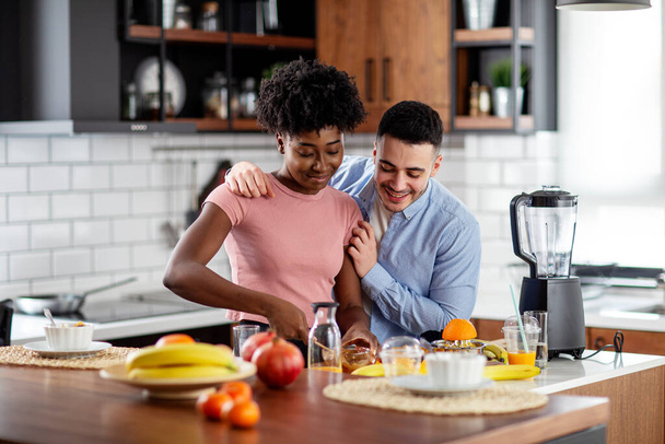 Νεαρό ζευγάρι στην κουζίνα διασκεδάζουν με φρούτα - Φωτογραφία, εικόνα