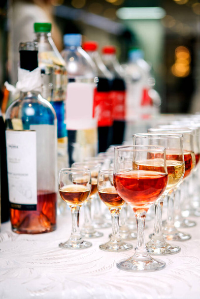flessen, glazen en glazen op de feesttafel staan op een rij - Foto, afbeelding