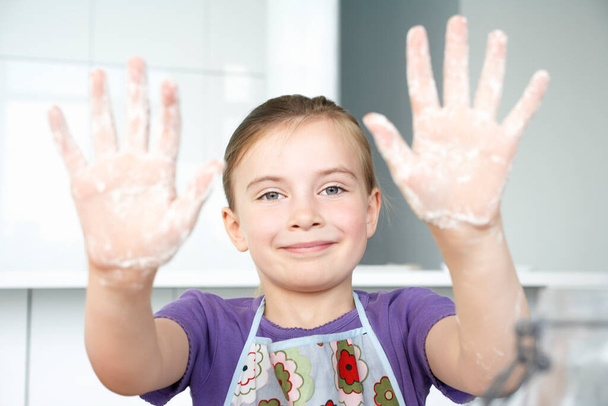 Girl showing hands covered in flour portrait - Zdjęcie, obraz