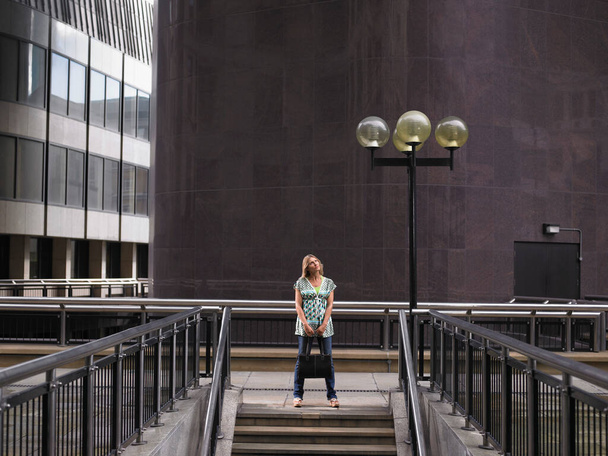 Woman standing at top of steps - Foto, afbeelding
