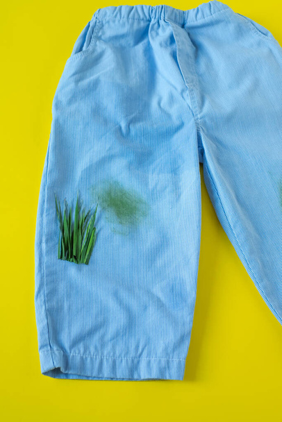 Grasflecken auf Pants.isolated auf gelbem Hintergrund - Foto, Bild