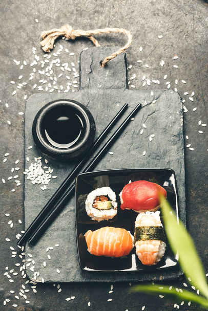 Sushi set on dark vintage background, flat lay - Фото, изображение