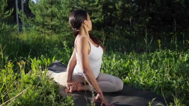 Młoda kobieta praktykuje jogę w przyrodzie - Materiał filmowy, wideo