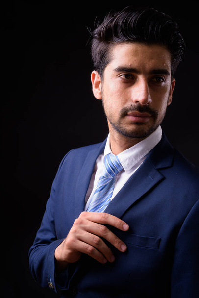Estudio toma de joven guapo barbudo persa empresario sobre fondo negro - Foto, imagen