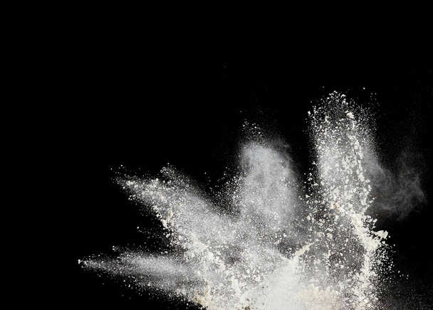 nuvem de farinha de trigo branco sobre um fundo preto, partículas voam em direções diferentes, explosão e respingo - Foto, Imagem