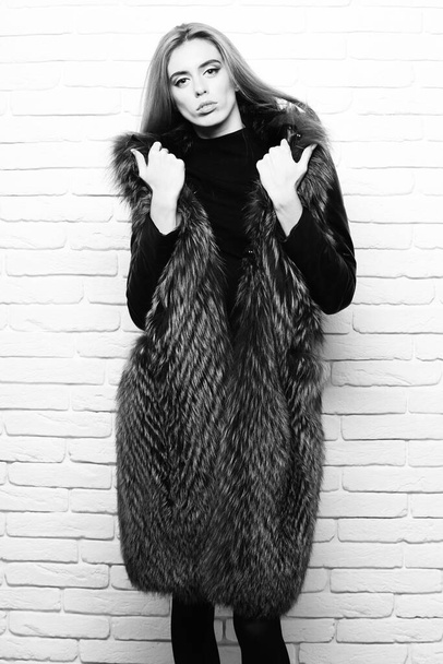 fashionable sexy woman in fur on white brick wall studio background - 写真・画像