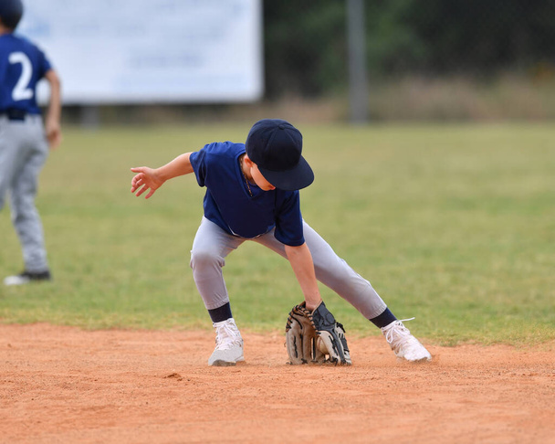 Actie foto van knappe jonge honkbalspeler het maken van verbazingwekkende speelt tijdens een honkbalwedstrijd - Foto, afbeelding