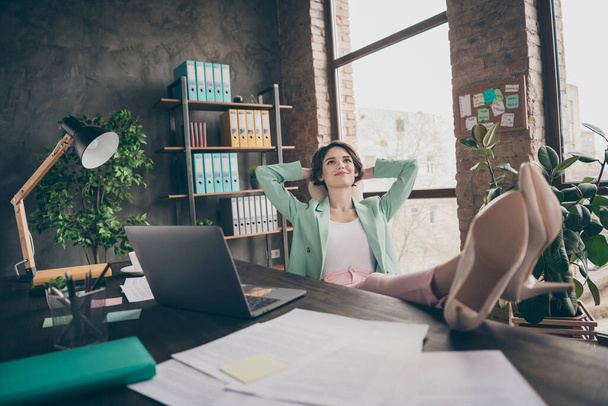 Profile photo of beautiful business lady hold hands behind head look up dreamy imagination flight minded resting remote distance work legs on table sit big chair office indoors - Foto, Imagen