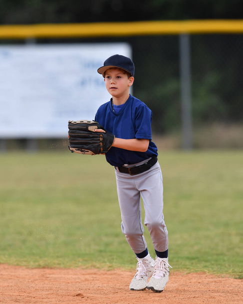 Foto de ação de belo jovem jogador de beisebol fazendo jogadas incríveis durante um jogo de beisebol
 - Foto, Imagem