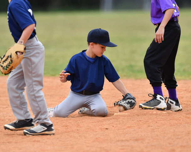 Zdjęcie akcji przystojny młody baseballista podejmowania niesamowite gry podczas meczu baseballowego - Zdjęcie, obraz