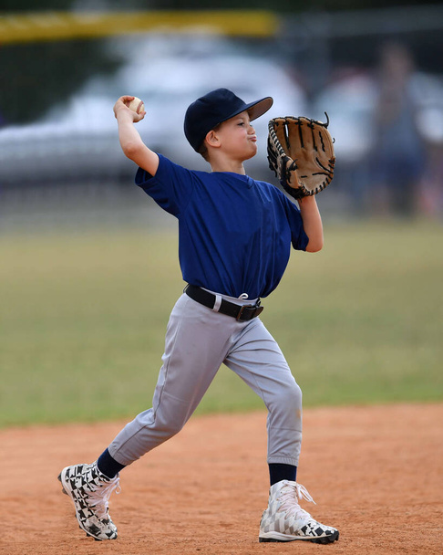 Φωτογραφία δράσης του όμορφου νεαρού παίκτη του μπέιζμπολ κάνει καταπληκτικά παιχνίδια κατά τη διάρκεια ενός παιχνιδιού μπέιζμπολ - Φωτογραφία, εικόνα