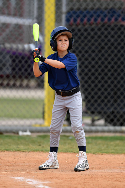 Foto de acción de joven jugador de béisbol guapo haciendo increíbles jugadas durante un juego de béisbol
 - Foto, Imagen