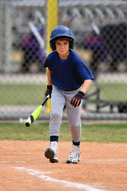 Action-Foto von hübschen jungen Baseballspieler macht erstaunliche Spiele während eines Baseball-Spiels - Foto, Bild