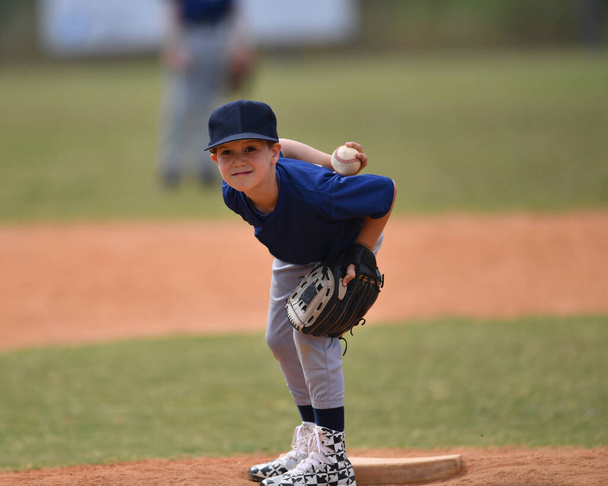 野球の試合中に素晴らしいプレーを作るハンサムな若い野球選手のアクション写真 - 写真・画像