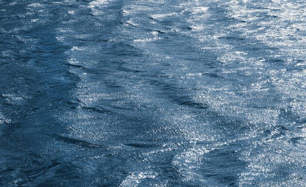 Background, texture from  waves, in which the sun reflects. Dark waves on the surface of the river in windy weather - Fotoğraf, Görsel