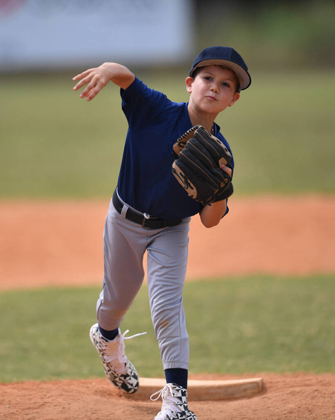 Zdjęcie akcji przystojny młody baseballista podejmowania niesamowite gry podczas meczu baseballowego - Zdjęcie, obraz