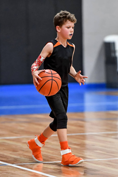 Jonge knappe jongen maakt geweldige basketbal speelt tijdens een wedstrijd - Foto, afbeelding