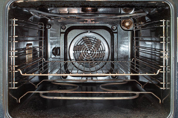 Binnenaanzicht van een gebruikte open vuile gebeitste oven en gegrilde metalen lade 2020 - Foto, afbeelding