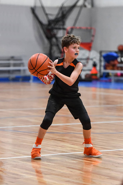 Jovem menino bonito fazendo grandes jogos de basquete durante um jogo
 - Foto, Imagem
