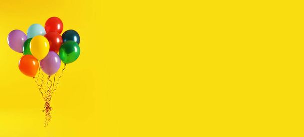 Bunch of bright balloons on yellow background, space for text. Banner design  - Foto, Imagem