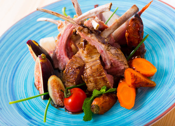 Tasty lamb ribs baked and served with vegetables and fresh figs - Foto, afbeelding