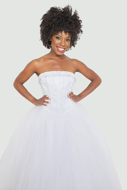 Portrait of pretty African American bride standing hands on hips against gray background - Foto, Imagem