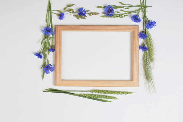 blue cornflowers and cereals with wooden frame on white background - Foto, afbeelding