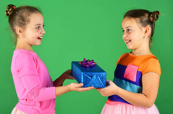 Crianças com rostos felizes posam com presentes no fundo verde
 - Foto, Imagem