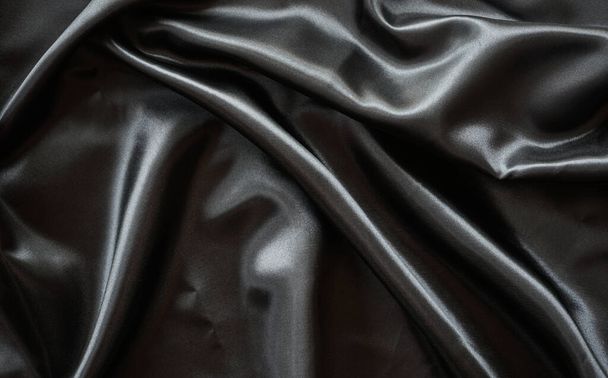 Falten schwarzes Satintuch Textur Hintergrund - Foto, Bild