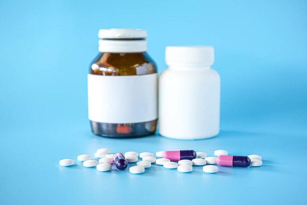 пузырек с таблетками для таблеток на синем фоне с избирательным фокусом - Фото, изображение