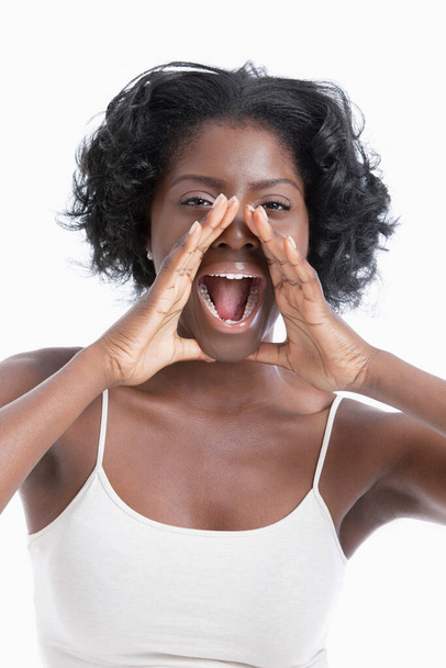 Portrait of a playful young woman shouting over white background - Fotó, kép
