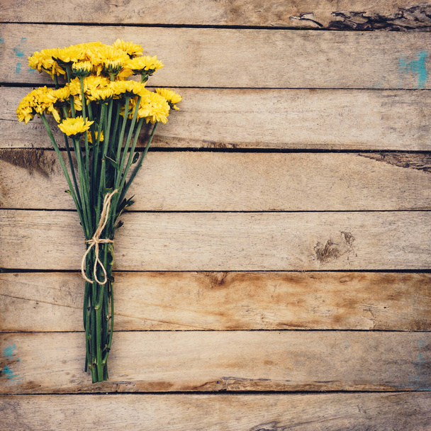 Yellow flowers of bouquet, top view on wooden background texture with copy space - Fotoğraf, Görsel