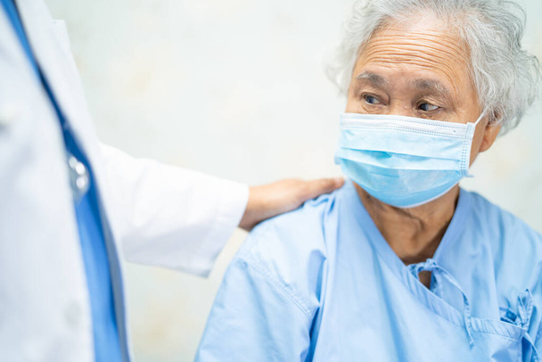 Azjatycki starszy lub starszy starsza pani pacjent nosi maskę twarzy w szpitalu w celu ochrony infekcji bezpieczeństwa i zabić Novel Coronavirus Covid-19. - Zdjęcie, obraz