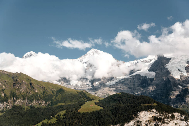 Vista panoramica sui monti verdi e sul cielo nella Valle di Lauterbrunnen, Svizzera - Foto, immagini