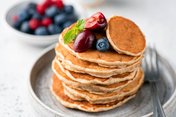 Healthy oat pancakes with berries on a plate. Vegan gluten free pancakes - Fotó, kép