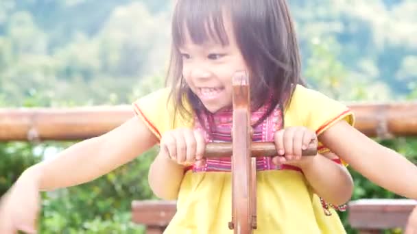 Happy sibling sisters playing with wooden rocking horse in the park. Concept of happiness in childhood. - Footage, Video
