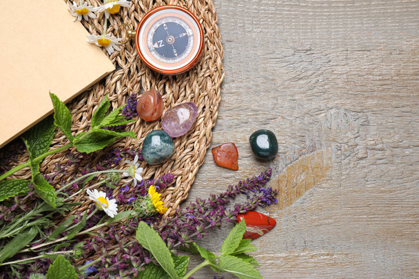 Flat lay composition with different gemstones and healing herbs on wooden table, space for text - Valokuva, kuva