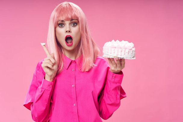 誕生日ケーキと美しいです女性でピンクウィッグ誕生日ピンクの背景 - 写真・画像