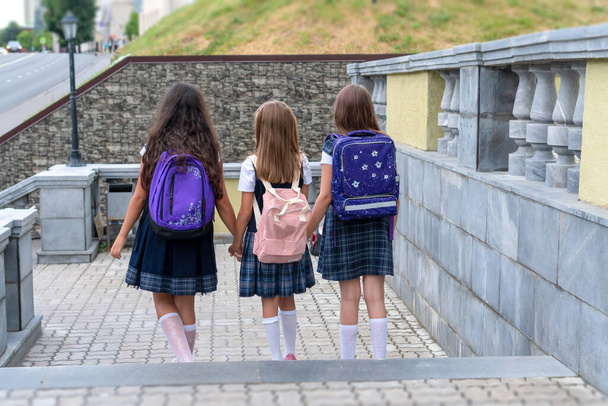 Respaldos de escolares con mochila colorida moviéndose en la calle
 - Foto, imagen