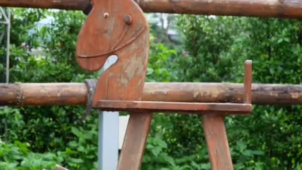Il cavallo a dondolo in legno che si muove nel parco all'aperto. - Filmati, video