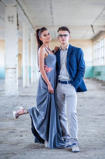 Prom couple. Handsome guy in blue suit and beautiful girl in glamorous silver blue dress, ready for their prom night - Foto, Bild