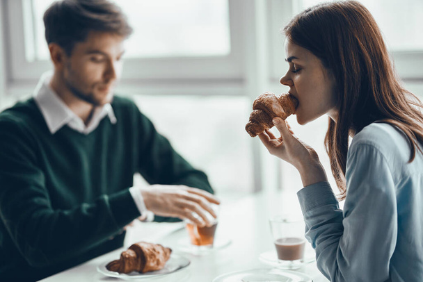 Мужчина и женщина кафе едят круассан завтрак  - Фото, изображение