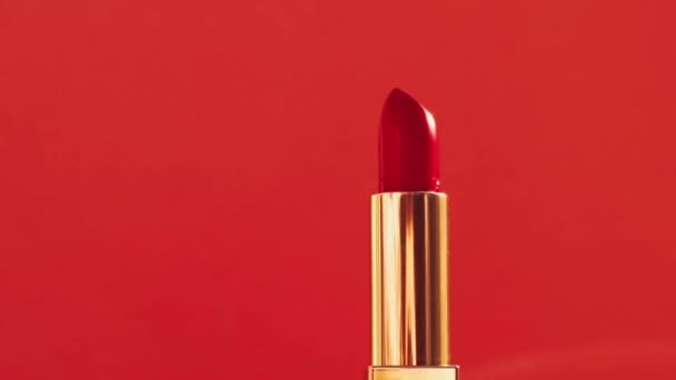 Lápiz labial rojo en tubo dorado y destellos de luz brillante, producto de maquillaje de lujo y cosméticos de vacaciones para la marca de belleza
 - Metraje, vídeo