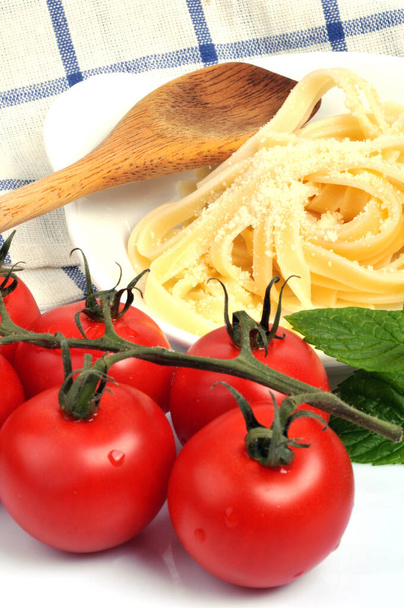 Prato de tagliatelle ao lado de tomate de videira close-up
  - Foto, Imagem