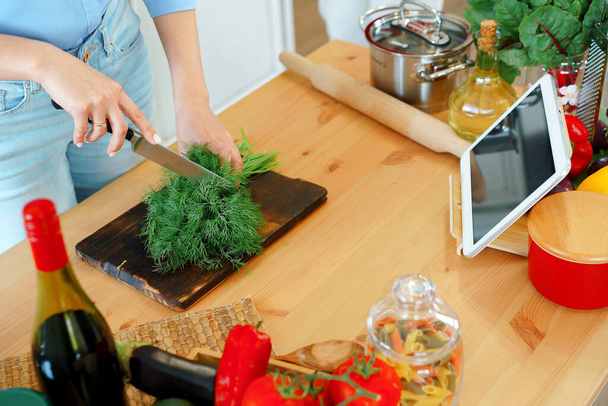 Молода блондинка біла жінка ріже овочі для салату на своїй кухні
 - Фото, зображення