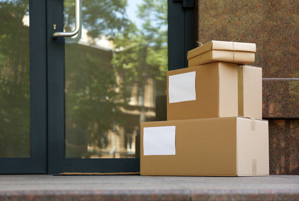 Delivered parcels on porch near front door - Фото, изображение