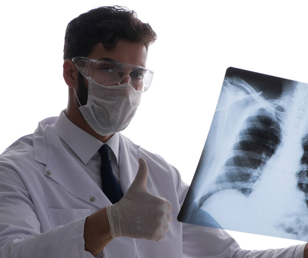 Молодой врач смотрит на рентгеновские снимки, изолированные на белом - Фото, изображение