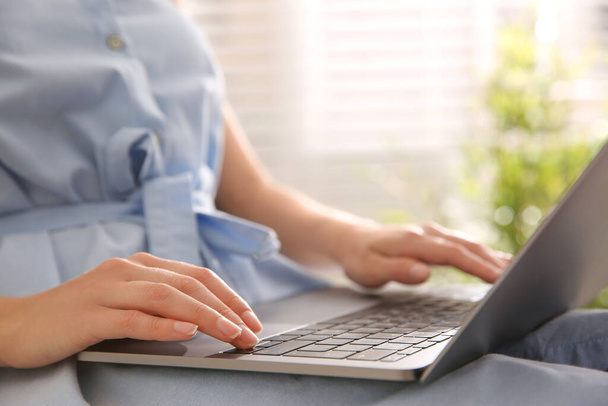 Mulher trabalhando com laptop moderno dentro de casa, close-up - Foto, Imagem