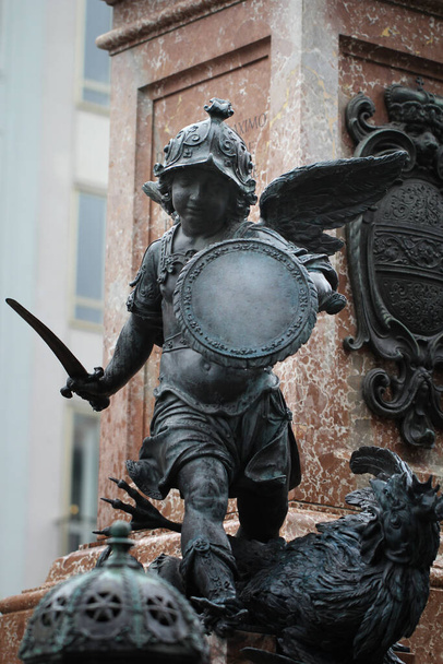 Közelkép ősi szobor Putto gyilkos ördög a Marian oszlop talapzatán Marienplatz, München, Németország, utazási cél háttér - Fotó, kép