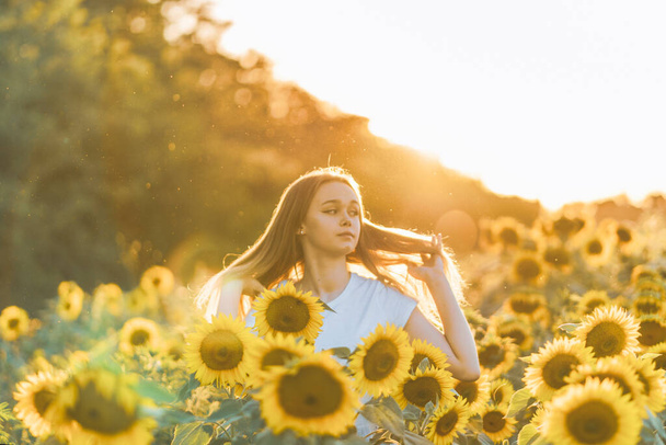 Молода красива жінка розважається в соняшниковому полі
 - Фото, зображення